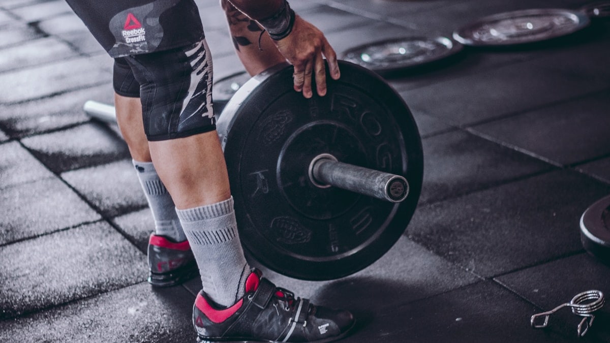 person holding black barbell plate